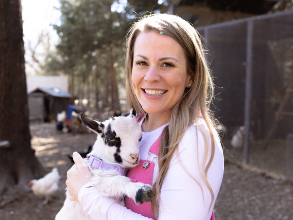 Lindsey holding a baby goat at Two Little Acres